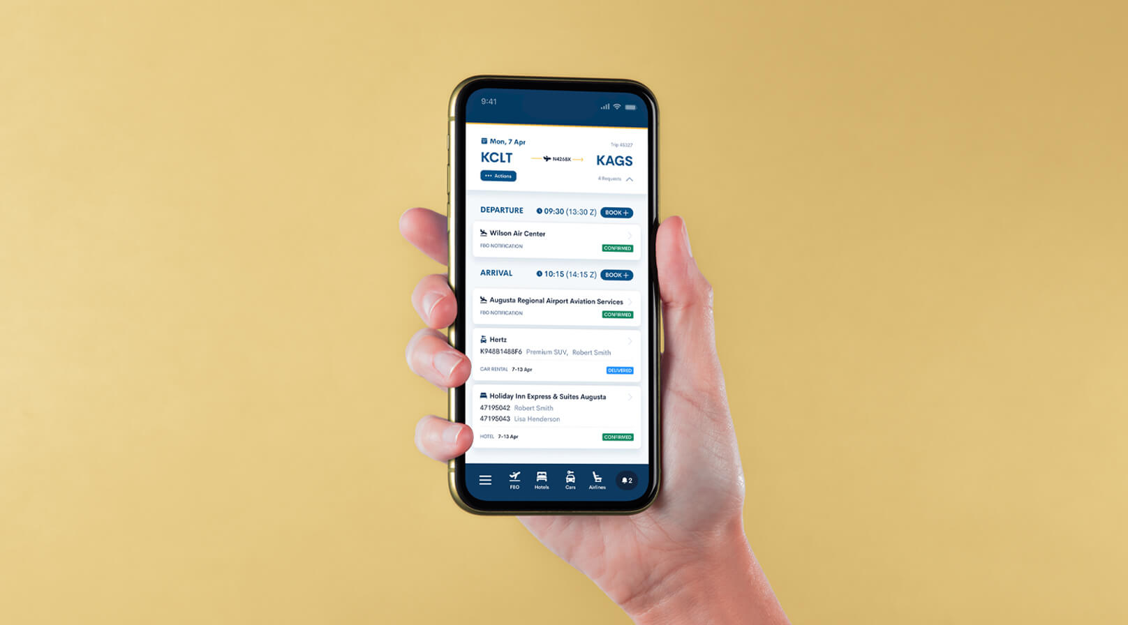 A hand holding a smartphone displaying the trip management app